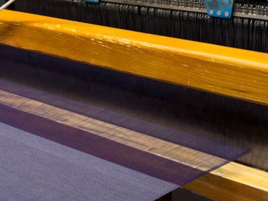 Dokuma, geleneksel el sanatları, dokuma tezgahının yakın çekimi, pamuk ve ipek iplik kullanarak esneme ve dokuma makinesini kullanarak örgü örmek..