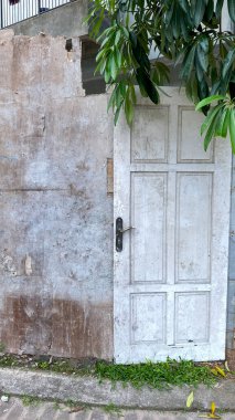 Beyaz kapı inşa edilen evin dışında duruyor.