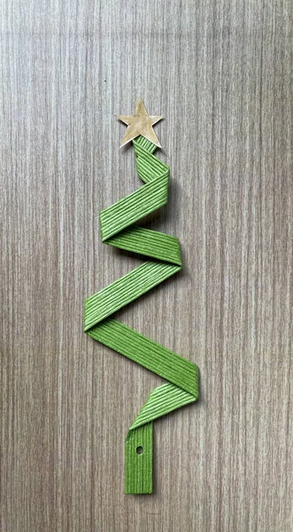 stock image Christmas tree made from green ribbon wire tape on wooden table. For copy space