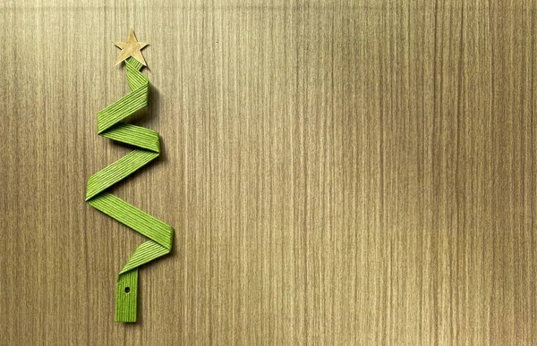 圣诞树是用木制桌子上的绿色丝带做成的 复制空间 — 图库照片