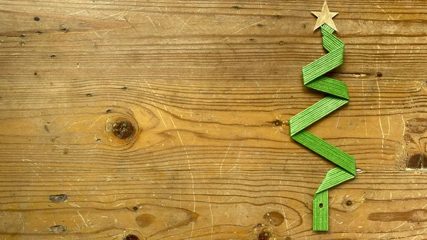 stock image Christmas tree made from green ribbon wire tape on wooden background