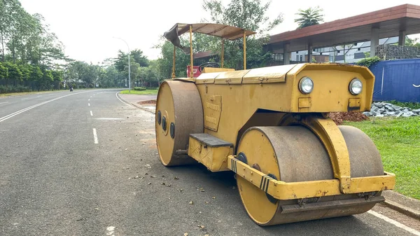 old rusty yellow road roller on the road