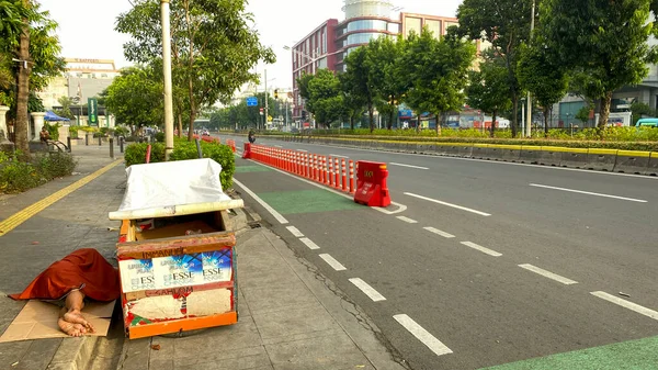 stock image Homeless man was sleeping beside his cart on pedestrian