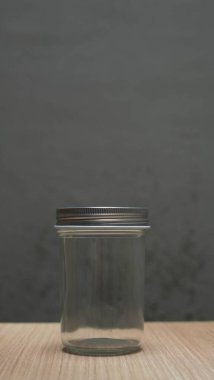 Ahşap masada kapalı boş cam kavanoz