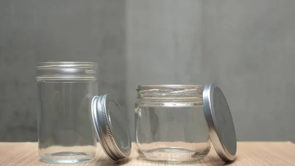 Zwei Geöffnete Glasgefäße Auf Holztisch Gegen Graue Wand — Stockfoto
