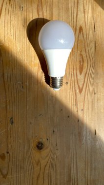 Tahta masada ampul var. Güneş ışığı bir el fenerinin ışığına benzer. İş yaratıcılığı ve ampulle ilgili ilham kavramları. - Evet. Başarı için motivasyon. Büyük fikirler düşün.