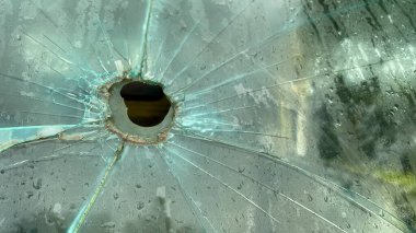 broken glass window with cracks and hole