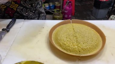 Kızartma tavasını takan bir kadın şefin yakın plan fotoğrafı.