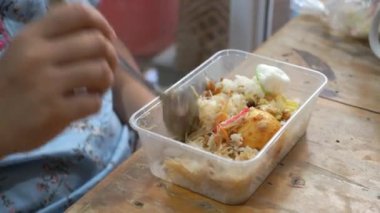 Asyalı adam tabakta tavuk yiyor..