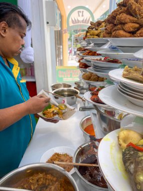 Satıcı Endonezya, Tangerang 'da bir Padang restoranında yemek hazırlıyor..