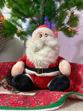 Noel Baba bebeğinin Noel ağacı süslemeleri ve arka planda hediyeleri olan yakın çekimi. Kış tatili kavramı 