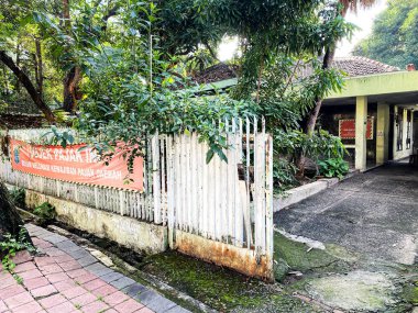 Çitlerde vergi borçlarını gösteren pankartı olan boş bir ev..