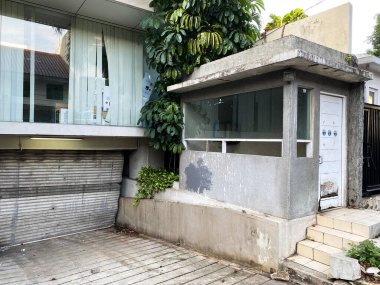 Kapısı ve penceresi olan küçük beton bir bina.