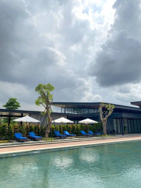 Endonezya 'da bir kulüp evinde yüzme havuzu. Bulutlu mavi gökyüzü ile güzel bir yüzme havuzu.