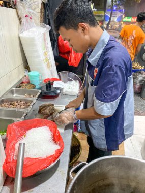İşçi, Jakarta 'da bir restoranın mutfağında yemek hazırlıyor.