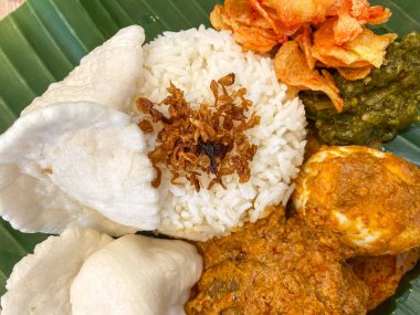 Nasi Uduk 'un en iyi manzarası, Tipik Endonezya Kahvaltı Yemeği. Hindistancevizi sütüyle pişirilmiş pilav, kızarmış tavuk, haşlanmış yumurta ve çıtır karides..