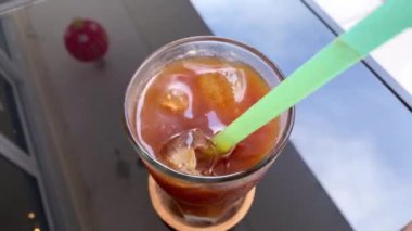 Bir bardak kırmızı içeceği tutan el.