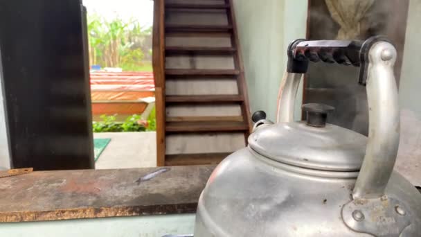 古いスチール製のシルバーケトルを蒸気で笛で沸騰させます キッチンカウンターのストーブトップケトル — ストック動画
