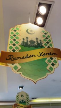 Ramadhan Karim 'in bir mağazanın tavanında asılı olduğunu gösteren süslemeler. Ramazan ayını selamlıyoruz. Dikey video