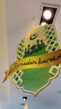 Ramadhan Karim 'in bir mağazanın tavanında asılı olduğunu gösteren süslemeler. Ramazan ayını selamlıyoruz. Dikey video