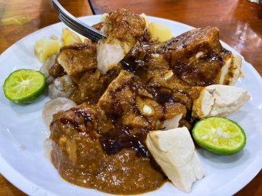 Endonezya yemeği, beyaz tabakta servis edilen pirinç ve soslu tavuk.