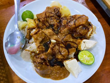 Kızarmış pirinç, balık ve sebzeli beyaz tabak.