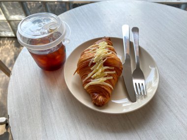 Bir fincan sıcak kahve ve kruvasan.