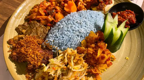 Mavi pirinç, doğal olarak Kelebek Bezelye Çiçeği ile renklendirilmiş, hindistan cevizi sütü ve pandan yapraklarıyla pişirilmiş, çeşitli mezeler ile servis edilmiş kızarmış tavuk, Tempeh, Tofu