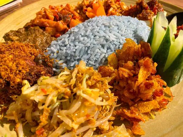 Mavi pirinç, doğal olarak Kelebek Bezelye Çiçeği ile renklendirilmiş, hindistan cevizi sütü ve pandan yapraklarıyla pişirilmiş, çeşitli mezeler ile servis edilmiş kızarmış tavuk, Tempeh, Tofu