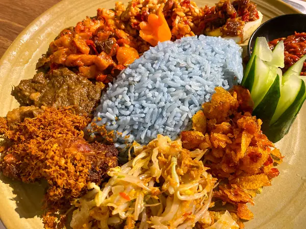 Mavi pirinç, doğal olarak Kelebek Bezelye Çiçeği ile renklendirilmiş, hindistan cevizi sütü ve pandan yapraklarıyla pişirilmiş, çeşitli mezeler ile servis edilmiş kızarmış tavuk, Tempeh, Tofu