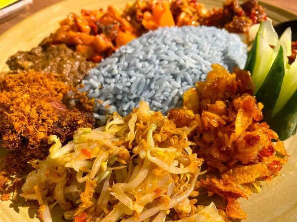 Mavi pirinç, doğal olarak Kelebek Bezelye Çiçeği ile renklendirilmiş, hindistan cevizi sütü ve pandan yapraklarıyla pişirilmiş, çeşitli mezeler ile servis edilmiş kızarmış tavuk, Tempeh, Tofu