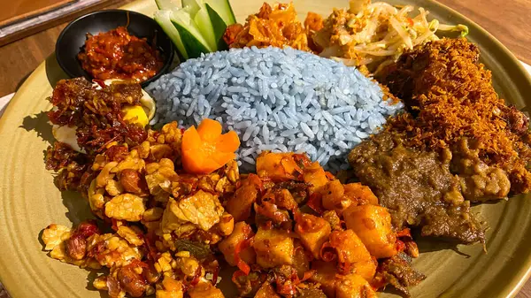 Mavi pirinç, doğal olarak Kelebek Bezelye Çiçeği ile renklendirilmiş, hindistan cevizi sütü ve pandan yapraklarıyla pişirilmiş, çeşitli mezeler ile servis edilmiş kızarmış tavuk, Tempeh, Tofu