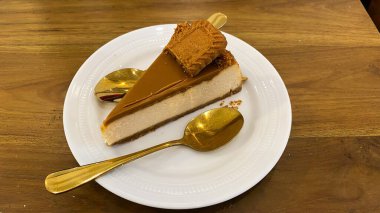 Tahta bir masada kremalı lezzetli bir pasta.