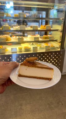 Bir parça kek tutan kadın.