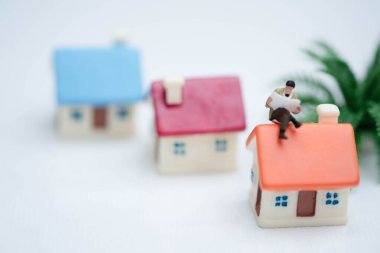 Minyatür insanlar iş adamı ev ve finans üzerine bir gazete okuyor.,