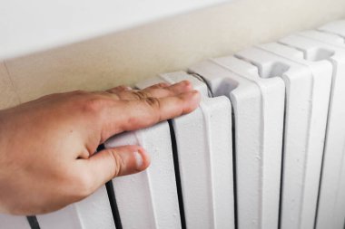 Bir adamın eli kışın evi ısıtmak için pil tutuyor.