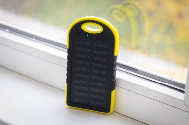 Gündüz vakti güneş pili olan sarı bir enerji bankası.