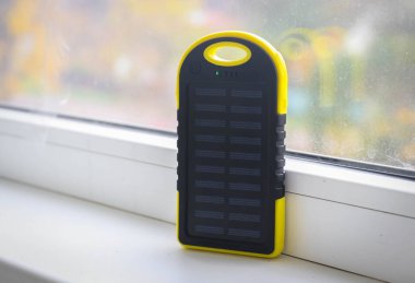 Gündüz vakti güneş pili olan sarı bir enerji bankası.