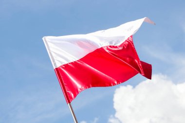 Gündüz vakti, mavi gökyüzünün arka planında Polonya 'nın ulusal bayrağı