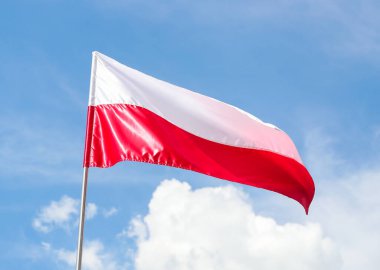 Gündüz vakti, mavi gökyüzünün arka planında Polonya 'nın ulusal bayrağı