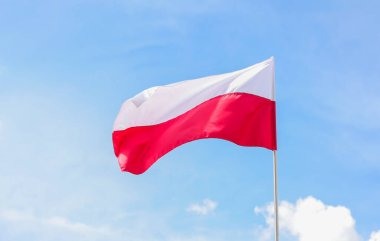 Gündüz vakti, mavi gökyüzünün arka planında Polonya 'nın ulusal bayrağı