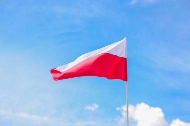 Gündüz vakti, mavi gökyüzünün arka planında Polonya 'nın ulusal bayrağı