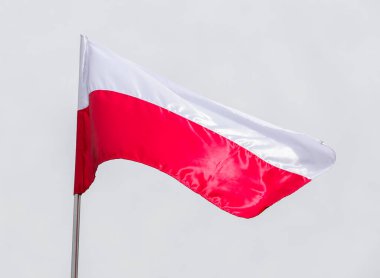 Gündüz vakti, mavi gökyüzünün arka planında Polonya 'nın ulusal bayrağı