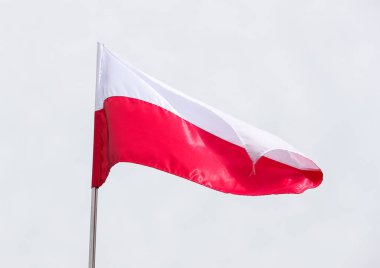 Gündüz vakti, mavi gökyüzünün arka planında Polonya 'nın ulusal bayrağı