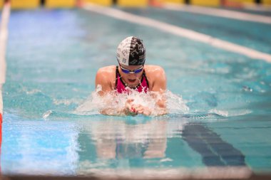 Poltava, Ukrayna - 23 Haziran 2023: Bir yüzücü Aquaarena 'da Ukrayna Gençler Yüzme Şampiyonası sırasında havuzda yüzer (spor kompleksi))