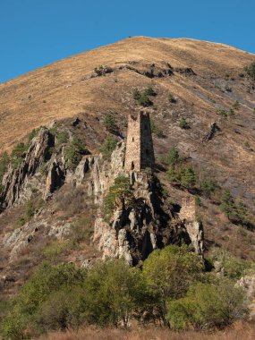Sunny afternoon in the Caucasus mountains. Medieval tower complex Vovnushki, one of the authentic medieval castle-type tower villages, located on the extremity of the mountain range in Ingushetia