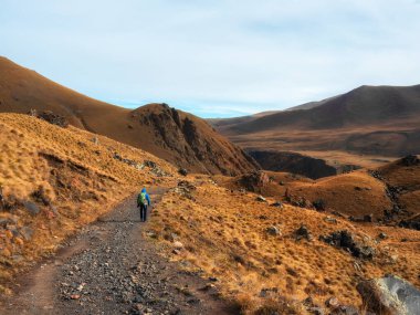 Autumn trekking on footpath alone Caucasus rocks. Solo trekking in the mountains. Travel photographer lifestyle, hiking hard track, adventure concept in autumn vacation.