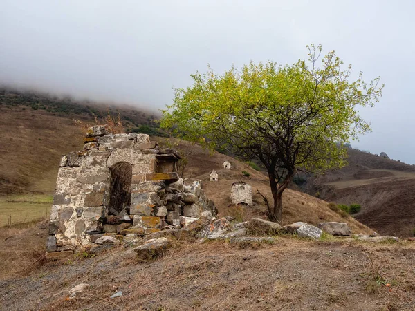 Old family crypt on a misty mountain slope. Old Erzi tower complex in the Jeyrah gorge, located on the extremity of the mountain range in Ingushetia, Russia.