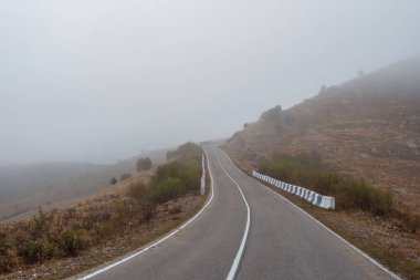 Soft focus. Empty morning mountain highway in a dense fog. Road through a dense fog.