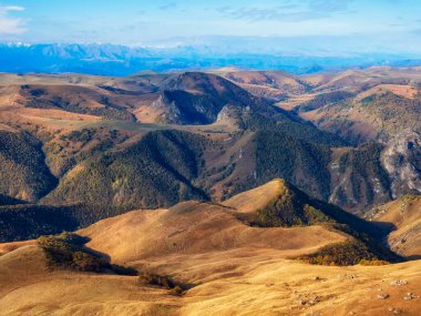 Sunny beautiful view of the Elbrus mountain region with a beautiful sky over the undulating landscape. Autumn mountain plateau, picturesque morning sunny view.  Elbrus National Park.
